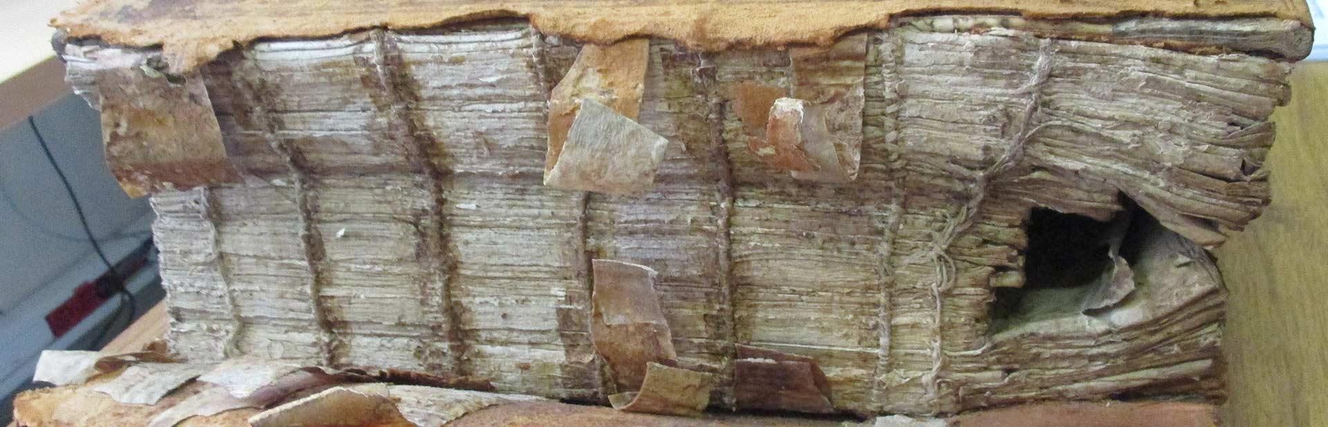 Livre gravement endommagé et vieilli avec reliure et pages cassées.