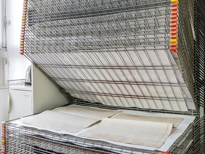 Pile de séchoirs contenant des morceaux de papier de couleur claire à l'intérieur.