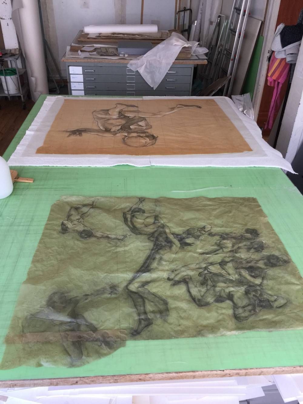 Deux dessins sur papier disposés sur une table, l'un représentant une figure, l'autre une composition similaire.