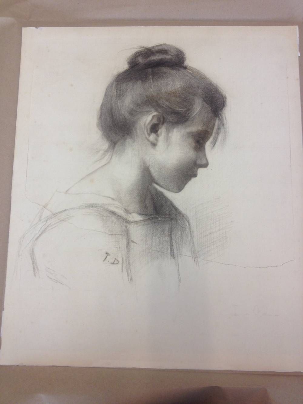 Croquis au fusain d'une personne aux cheveux relevés en chignon, regardant vers le bas. Un ombrage doux crée des jeux d'ombre et de lumière.