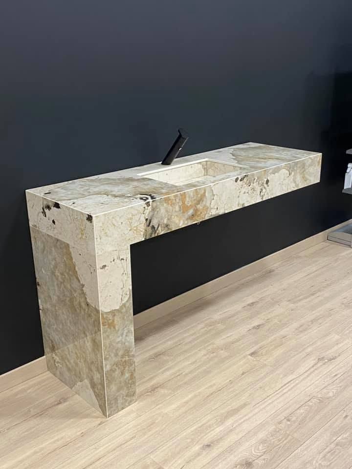 Console en pierre contre un mur sombre dans un intérieur minimaliste.