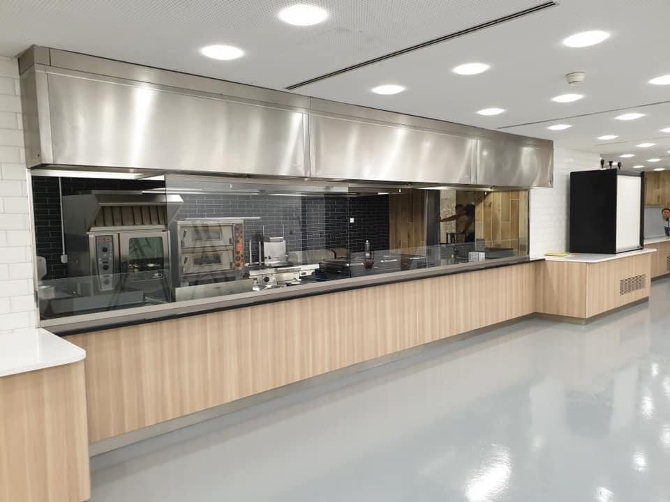 Cuisine moderne avec armoires en bois foncé, comptoirs en marbre et appareils électroménagers intégrés