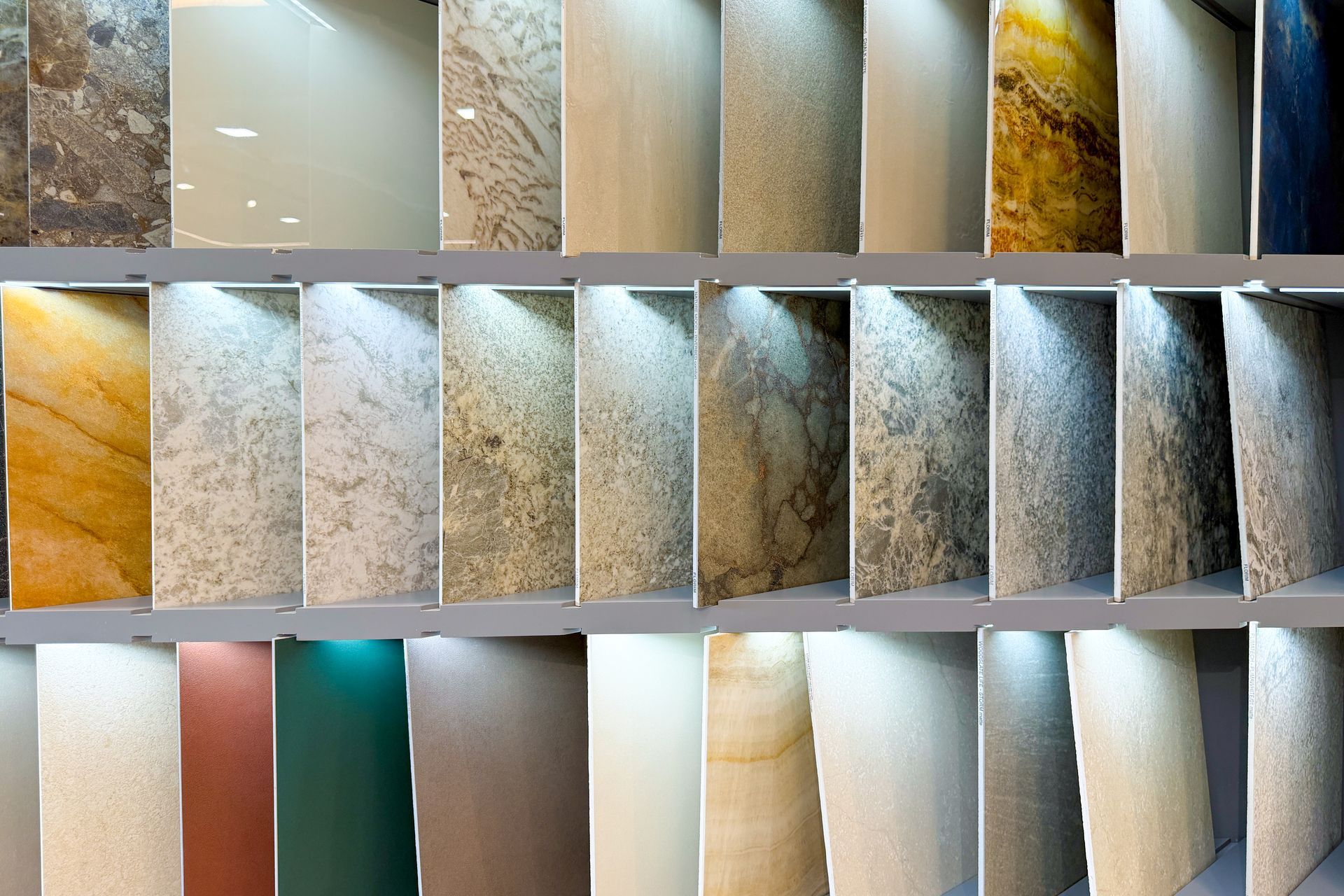 Échantillons de murs et de carrelages texturés dans des tons neutres, dorés, turquoise et blancs.