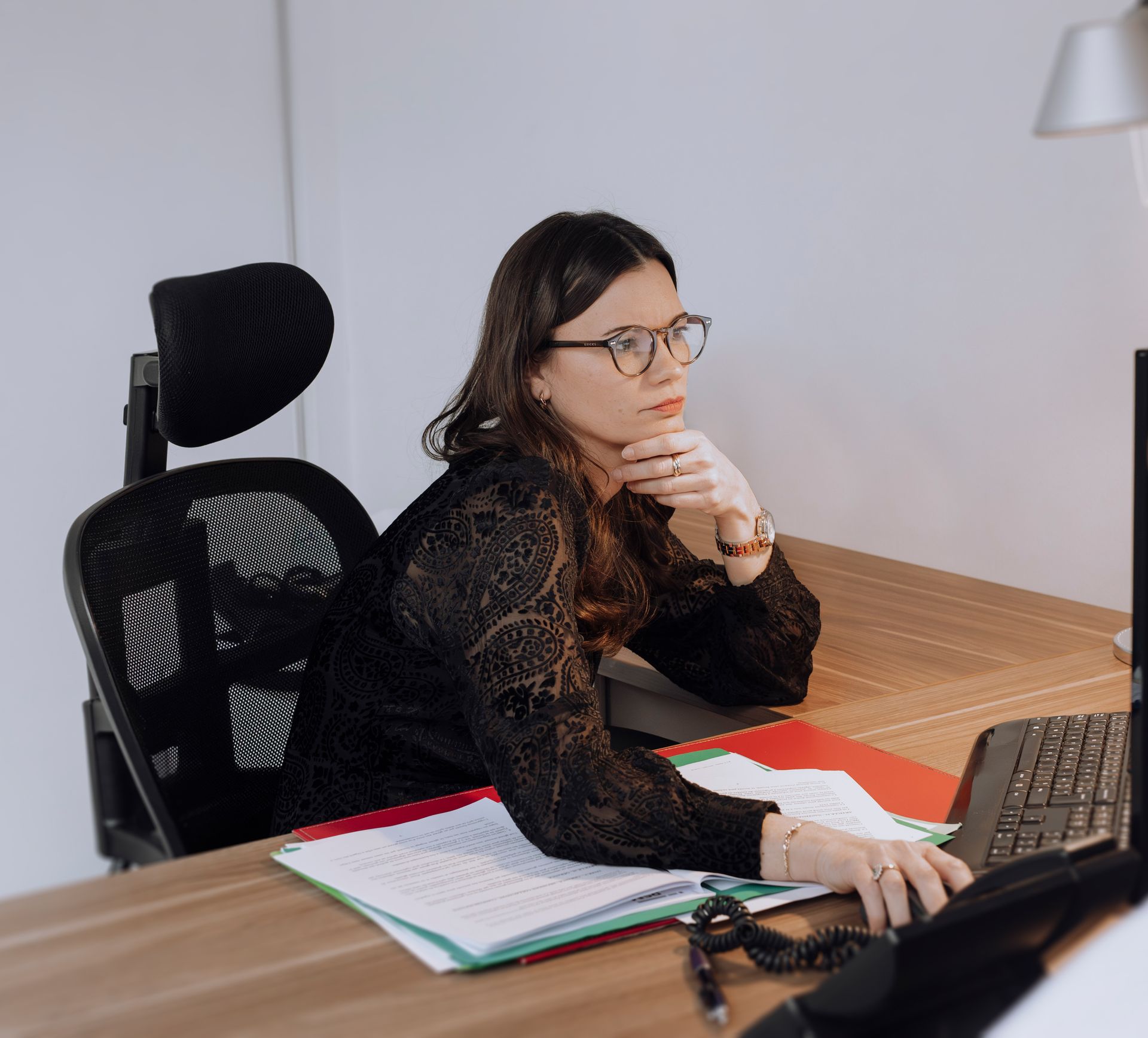 Jeune femme à lunettes en train de regarder un écran d'ordinateur