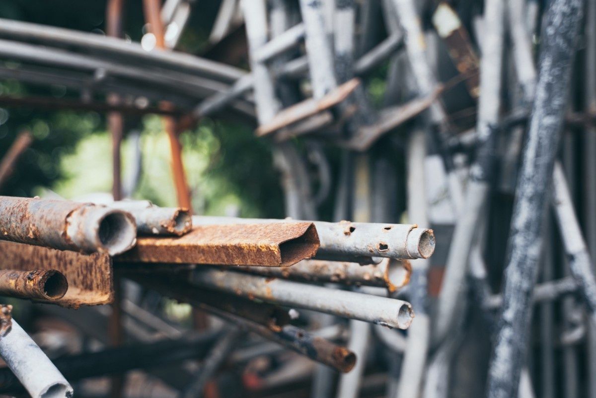 Pila de andamios de metal oxidado en un entorno al aire libre.