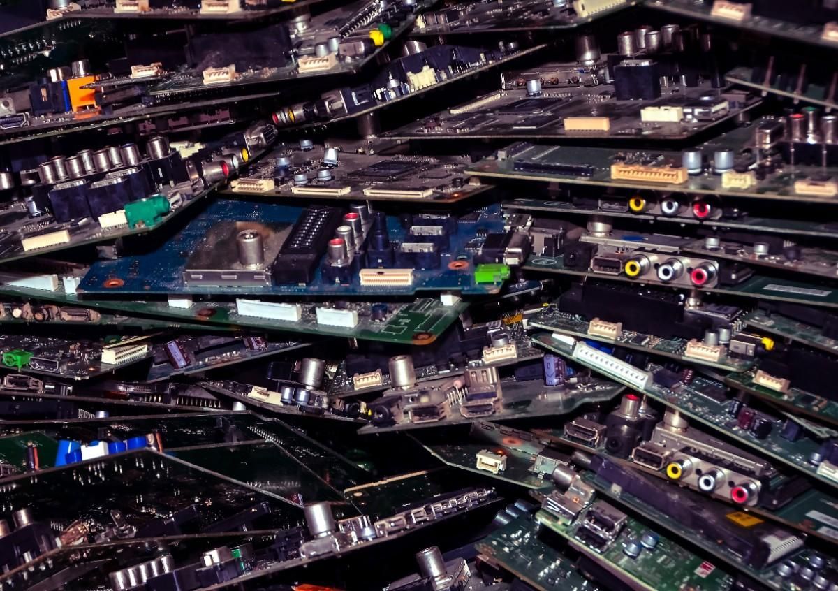 Pila de varias placas de circuitos electrónicos, verdes, azules y negros, apiladas aleatoriamente.