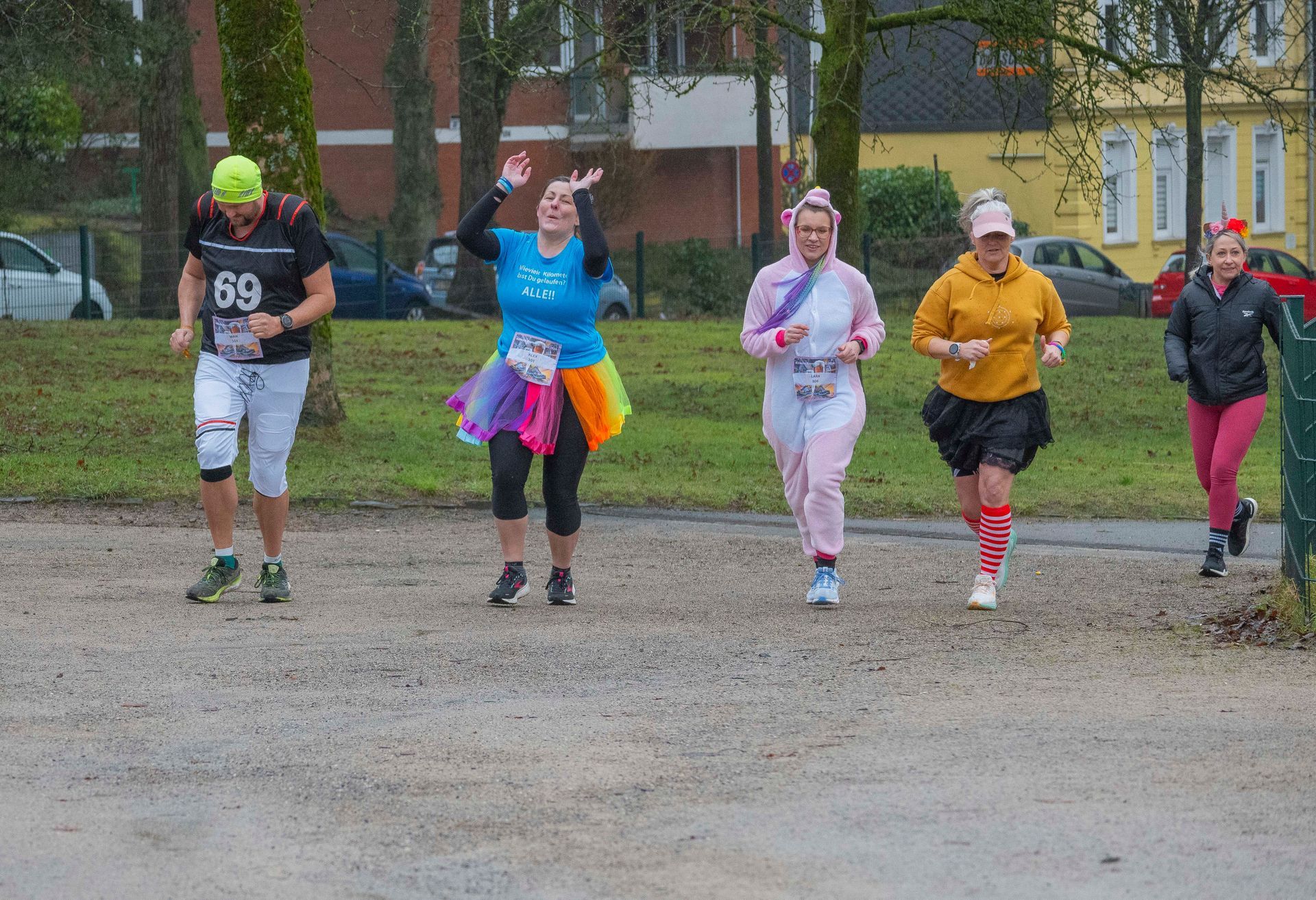 Läufer in Kostümen bei einem Rennen im Freien. 