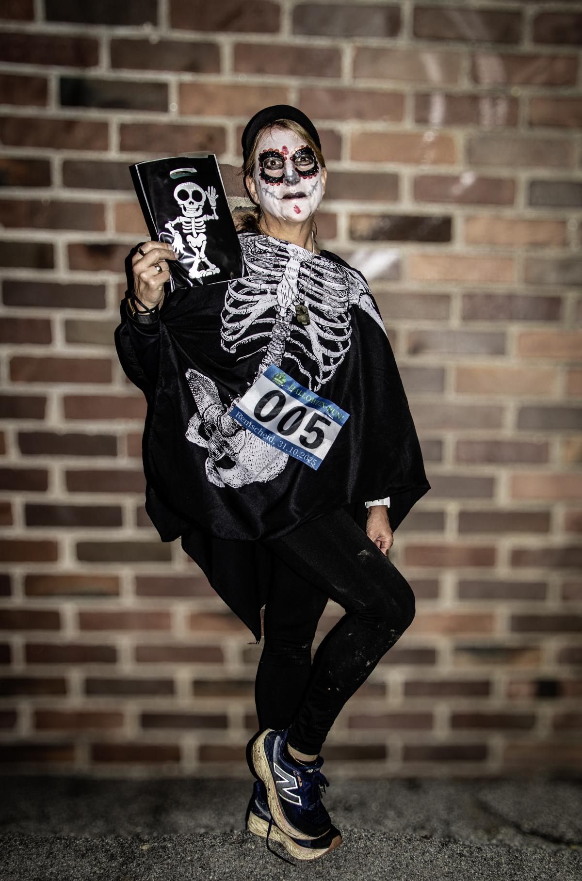 Vier Menschen laufen auf einem Weg. Sie tragen einzigartige Kostüme in einem Park. 