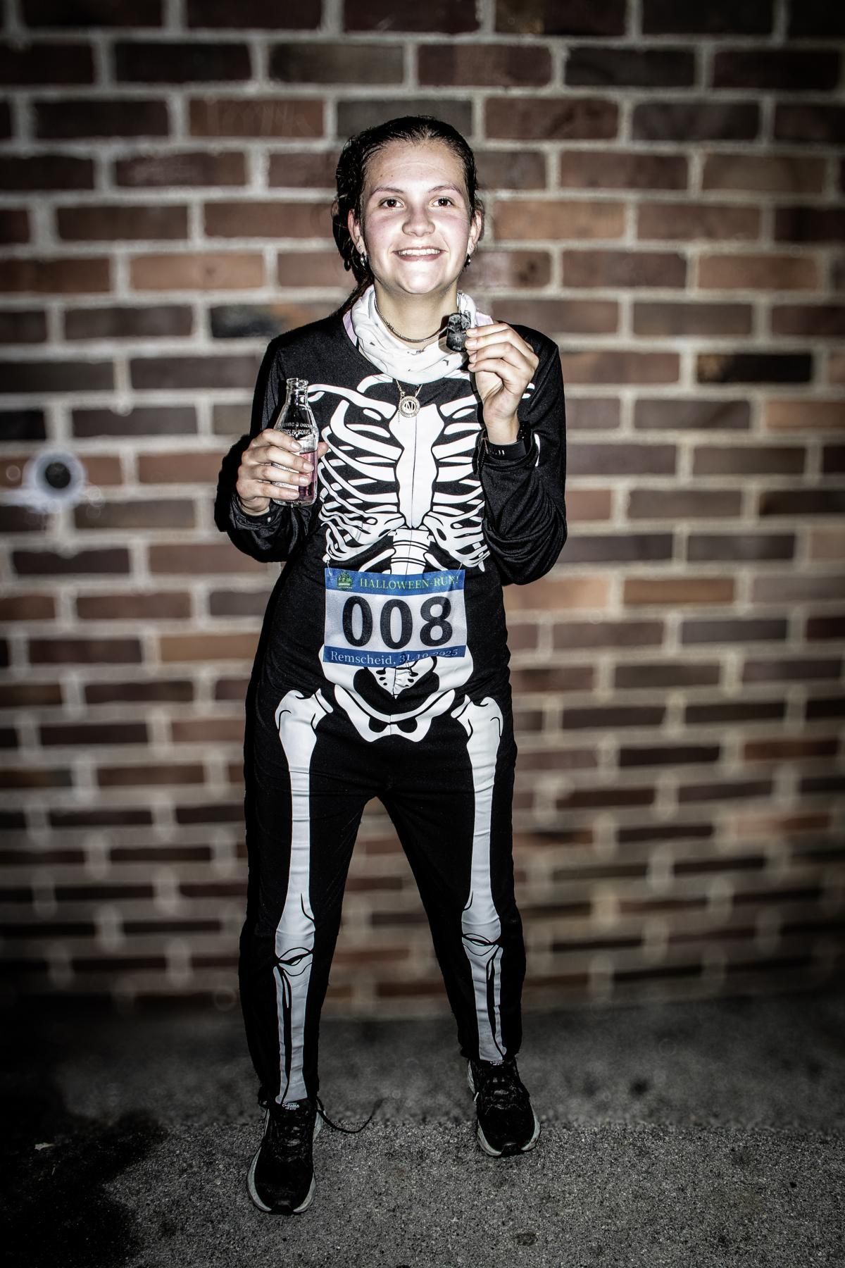 Vier Menschen in bunten Kostümen laufen auf einem Weg in einem Park.