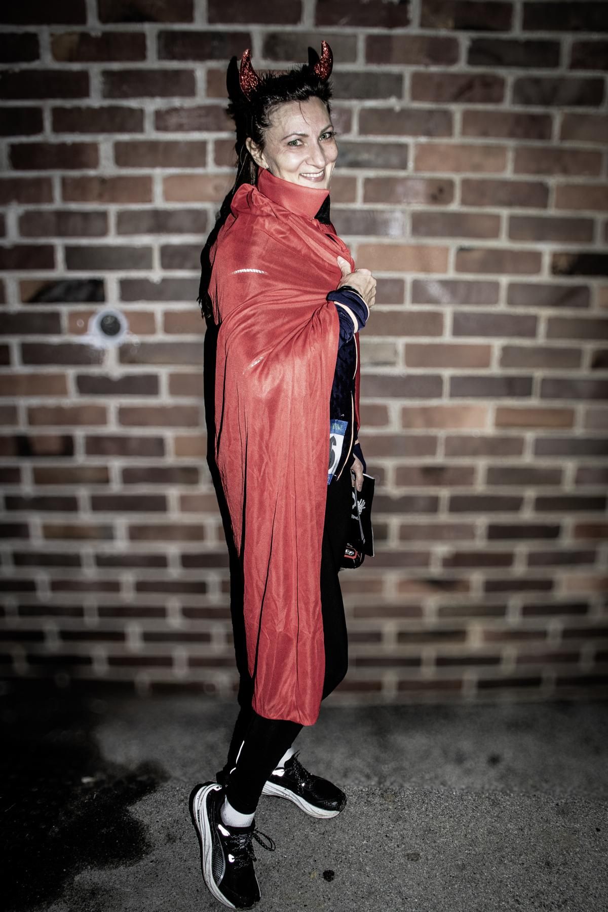 Mann und Frau lächeln, halten ein Bierschild, Frau im Bärenkostüm im Freien.