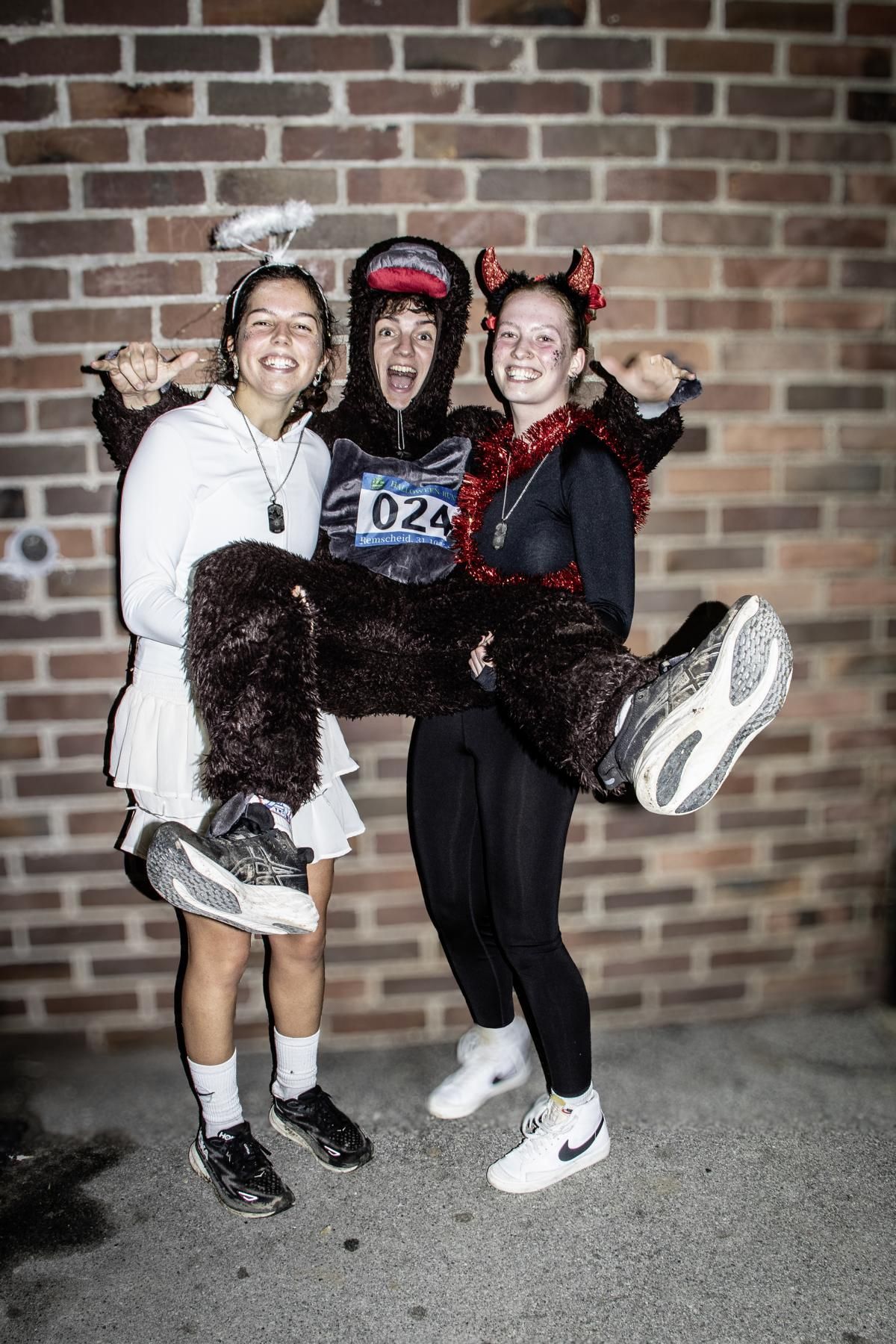 Drei Personen in eklektischen Outfits posieren im Freien. 