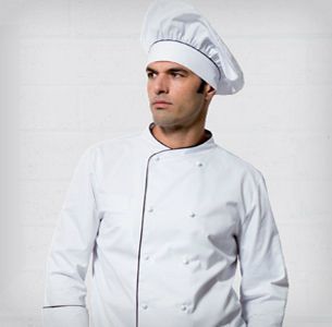 Un hombre que lleva un gorro y una chaqueta de cocinero blancos.
