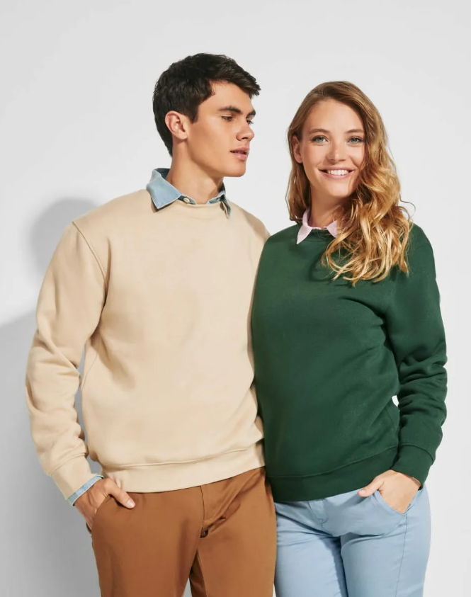 Un hombre y una mujer están parados uno al lado del otro vistiendo suéteres.