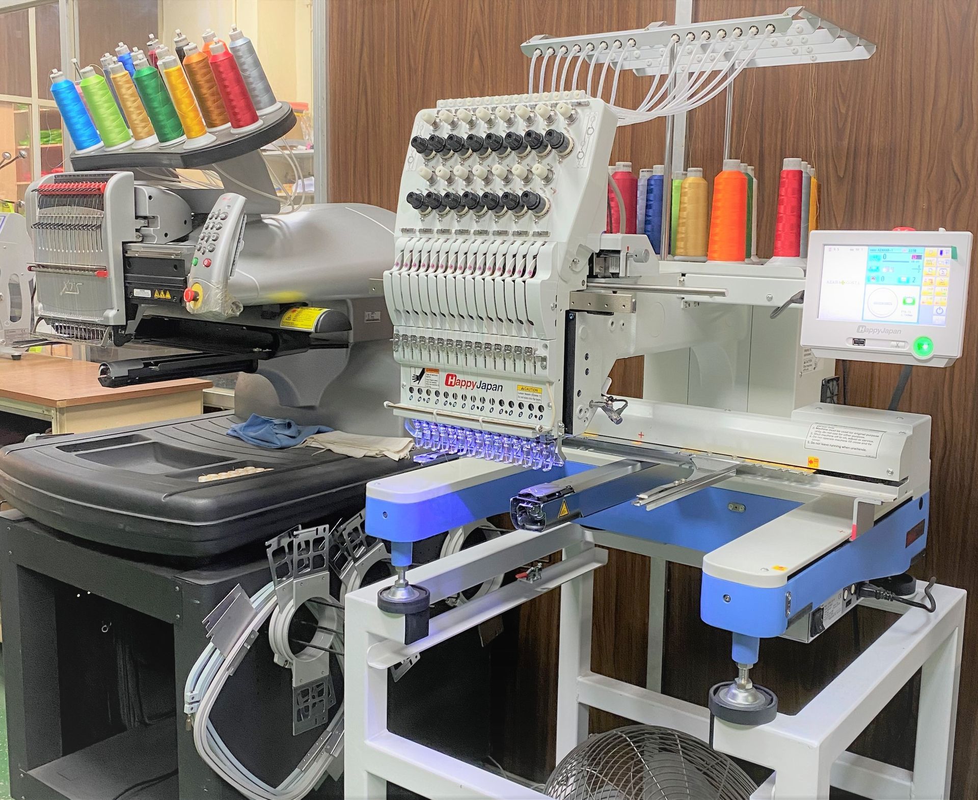 Una máquina con muchos carretes de hilo está colocada sobre una mesa.