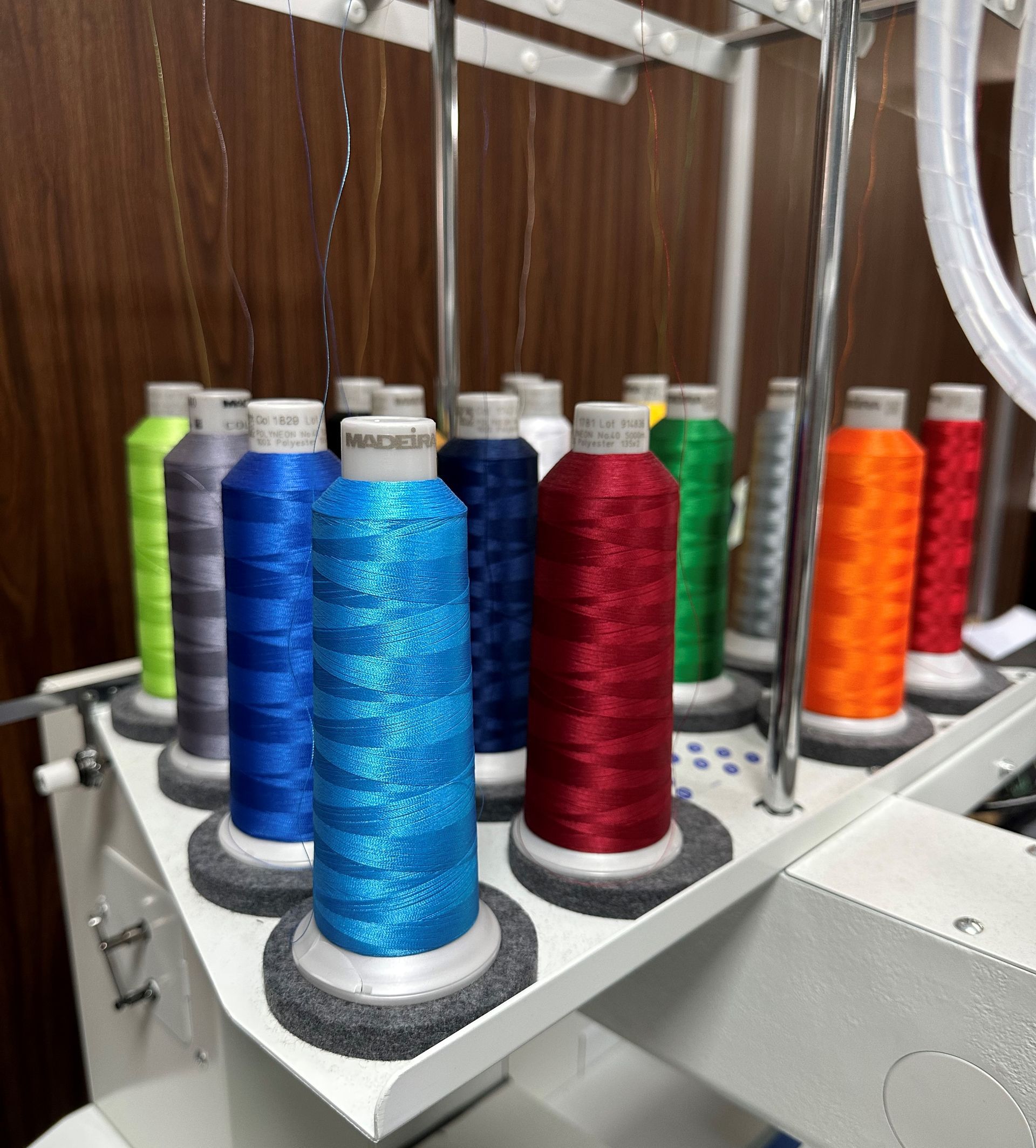 Un montón de carretes de hilo de diferentes colores en una máquina.