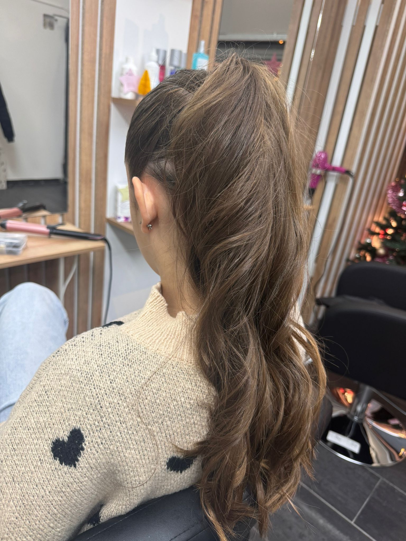 Chioma castana raccolta in una coda elegante.