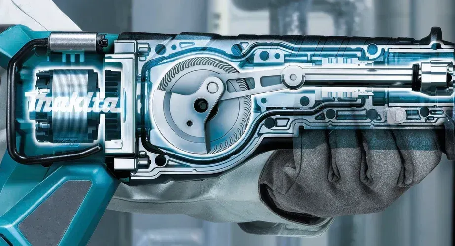 Querschnitt eines Makita-Elektrowerkzeugs, der die internen Zahnräder und die Mechanik in einer behandschuhten Hand zeigt