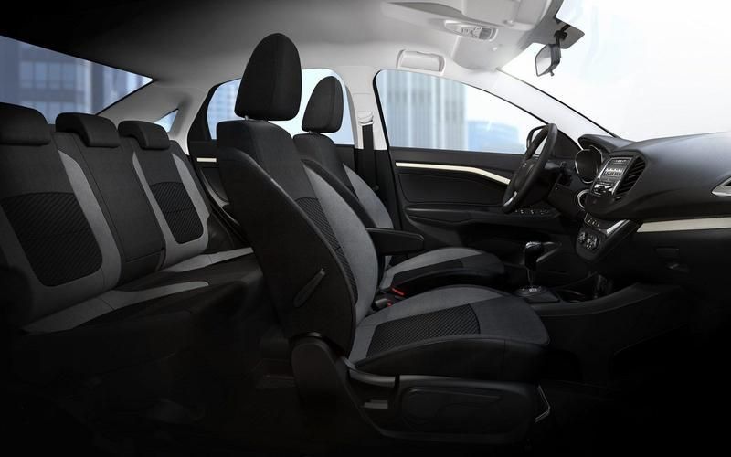 Der Innenraum eines Autos mit schwarz-weißen Sitzen und einem Lenkrad.