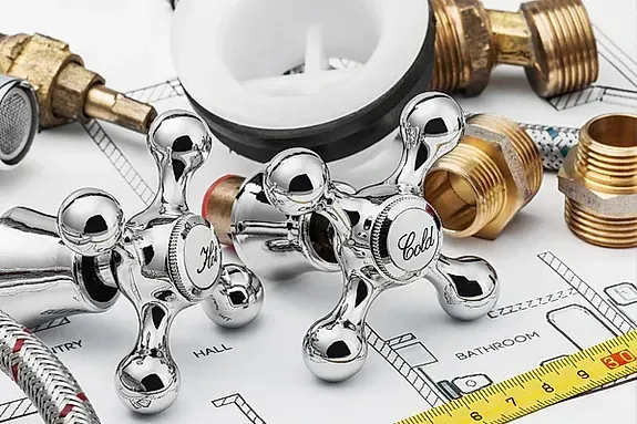 Un montón de piezas de plomería están colocadas encima de un plano.