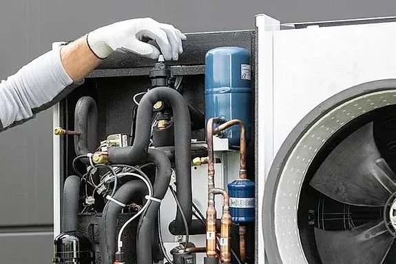 Una persona está trabajando en una máquina con un destornillador.