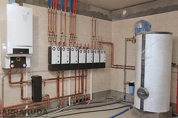 Una habitación con muchas tuberías y un calentador de agua.