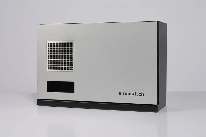 Ein silber-schwarzer Luftreiniger mit Lüftungsschlitz und Digitalanzeige, beschriftet mit „airomat.ch“.