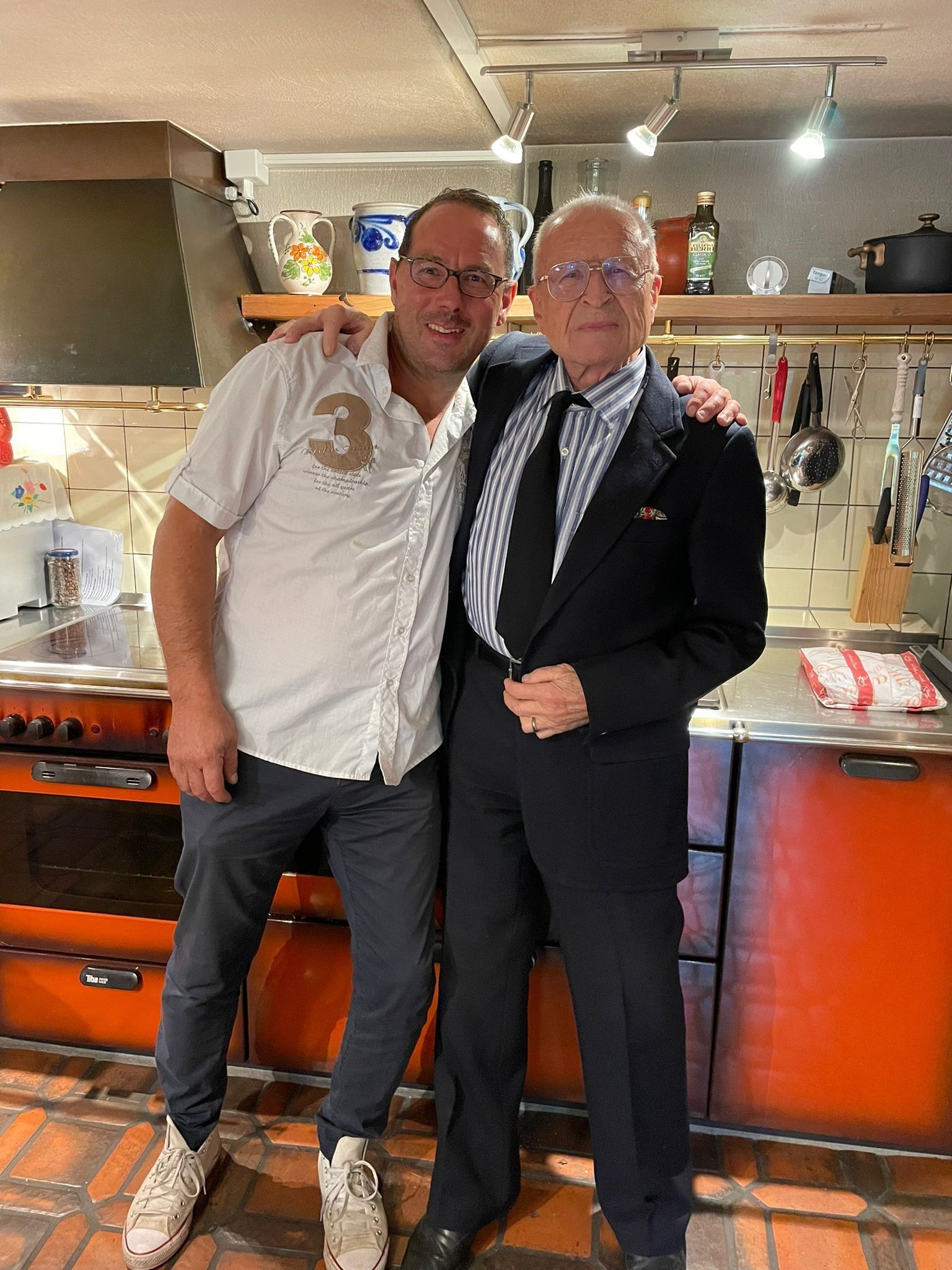 Zwei Männer posieren in einer Küche für ein Foto.