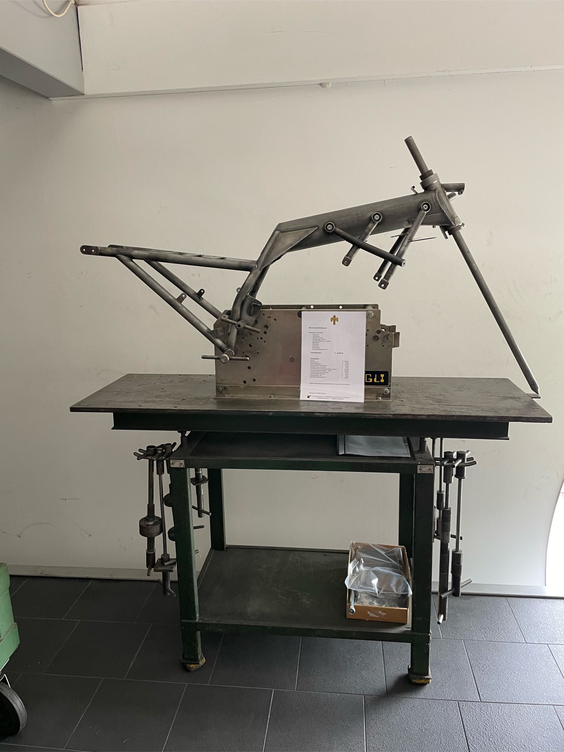 Ein Motorradrahmen liegt auf einer Werkbank