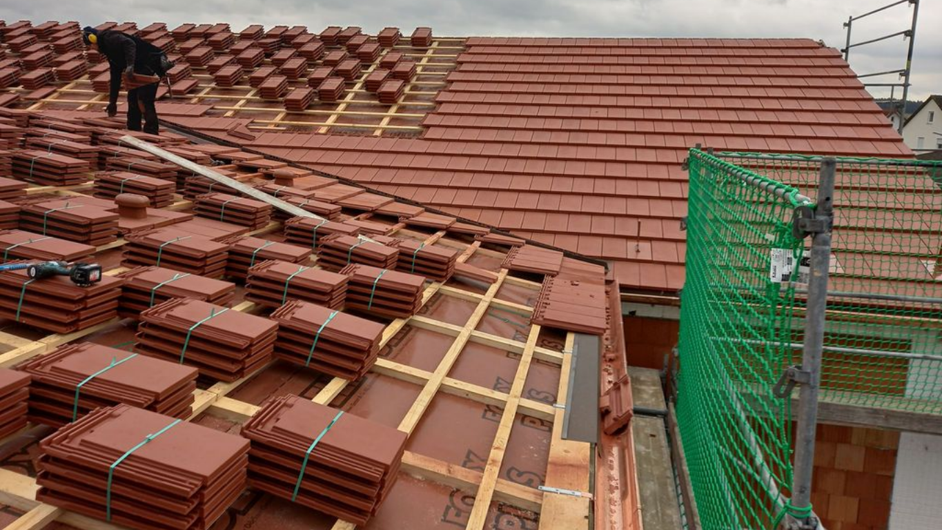 Verlegung von Holzparkett, Dielen im Fischgrätmuster mit Kleber und Kelle.