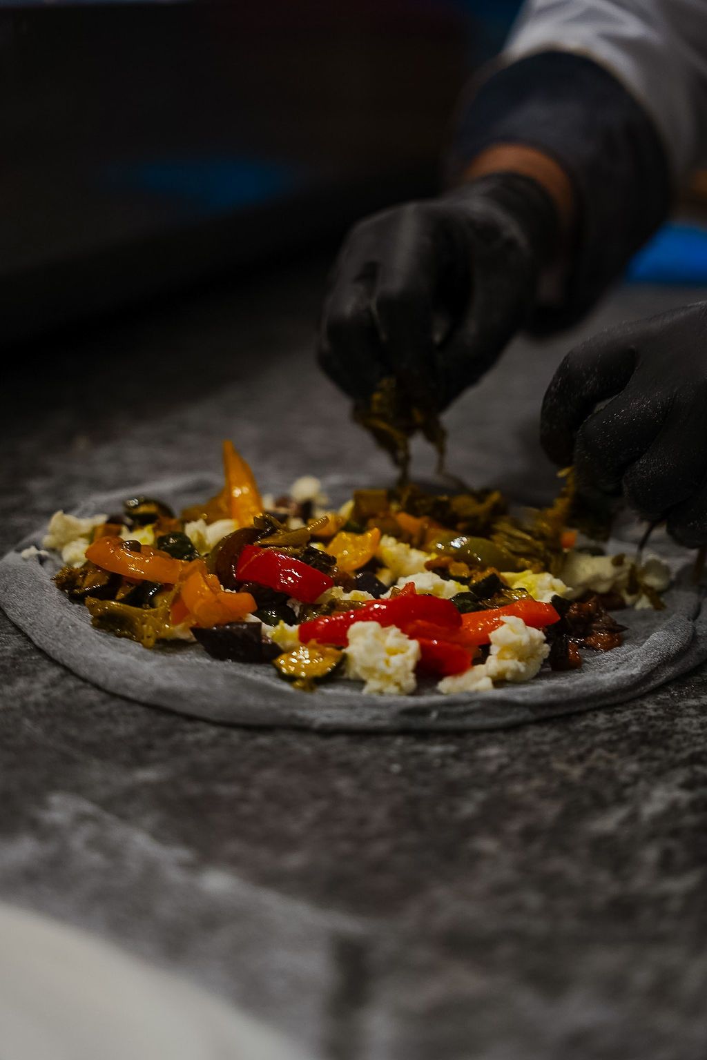 Un piatto rosso guarnito con tagliatelle, gamberi, cozze e granchio.