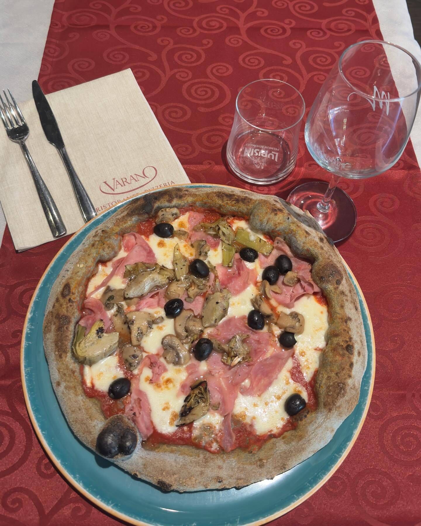 Una pizza è su un piatto blu su un tavolo