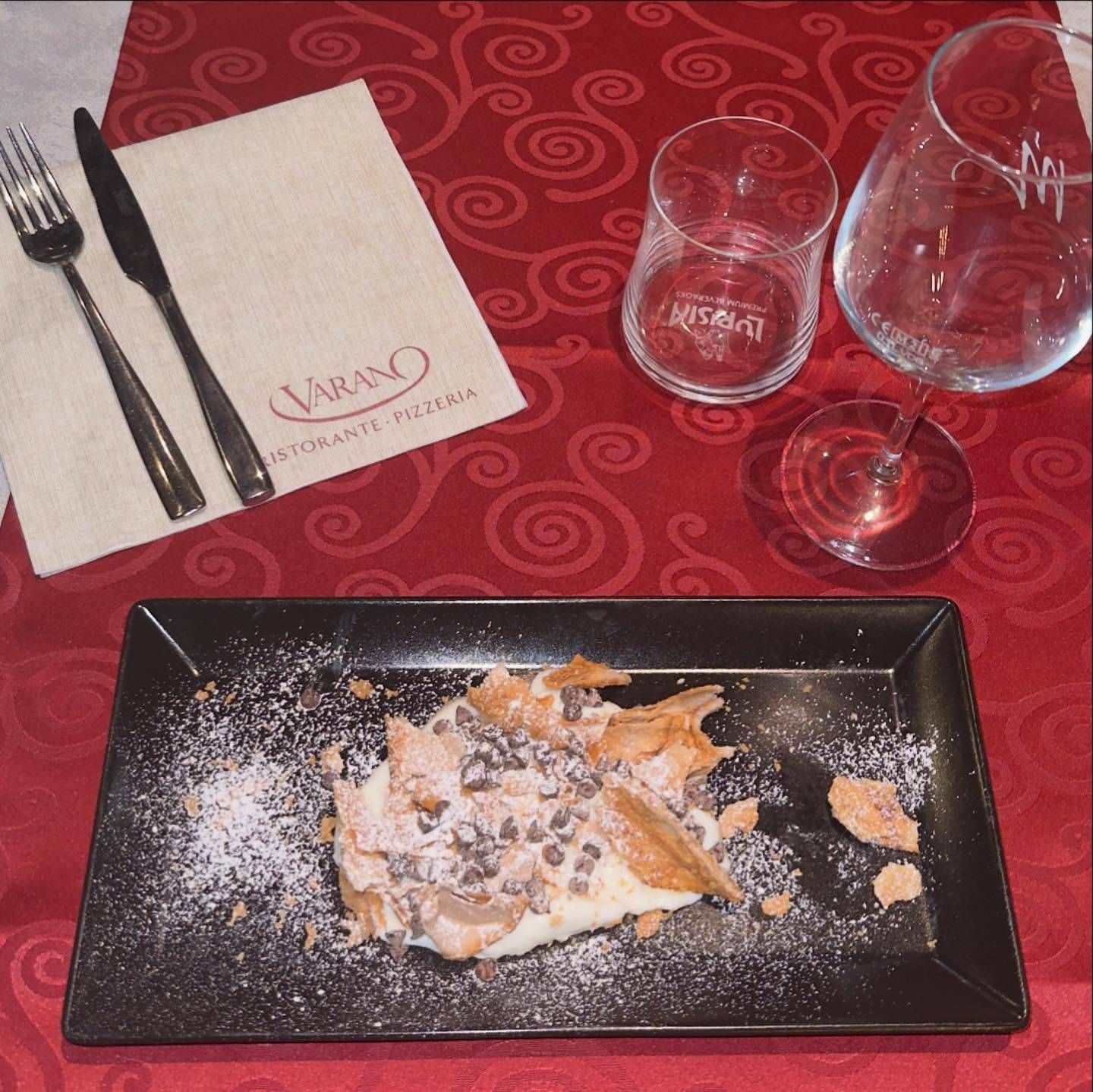 Un piatto di cibo è appoggiato su un tavolo con un tovagliolo su cui è scritto larano