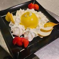 Un piatto di cibo con panna montata e frutta su un tavolo.