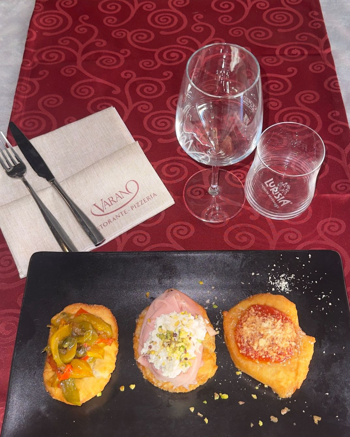 Una pizza è appoggiata su un piatto blu su un tavolo.