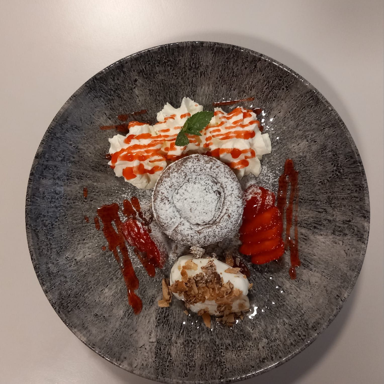 Un piatto di pasta con sugo di pomodoro e basilico su un tavolo.