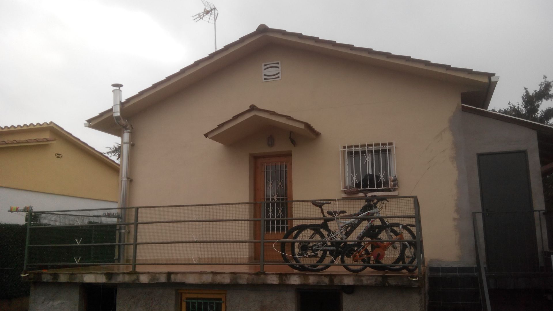 Dos bicicletas están aparcadas en el balcón de una casa.