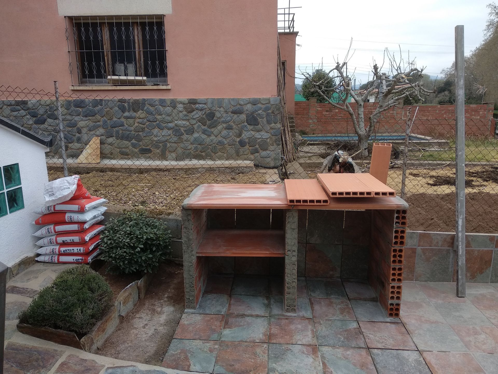 Un patio de ladrillo con una mesa frente a una casa.