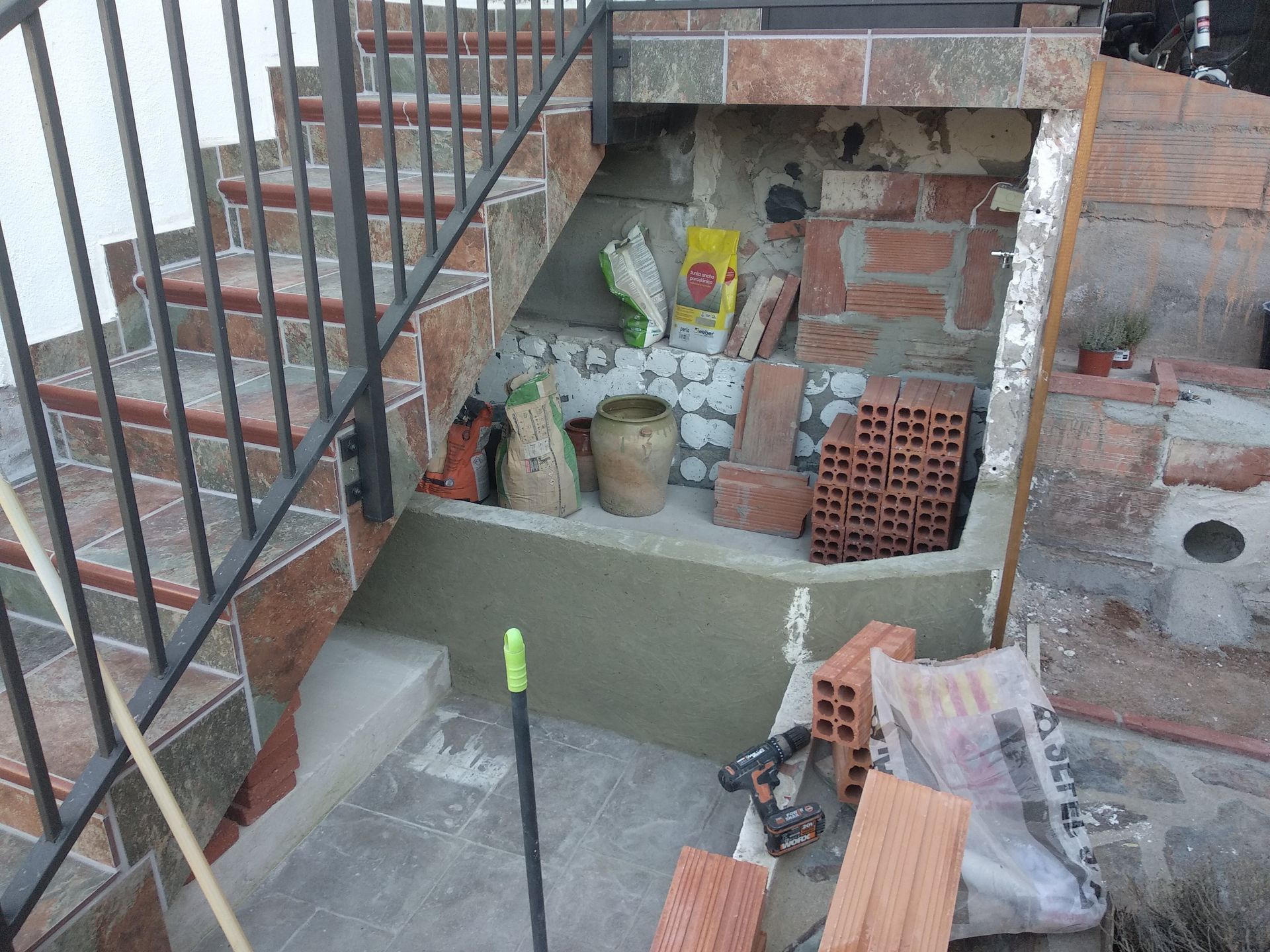 Se está construyendo una escalera con ladrillos y tejas.