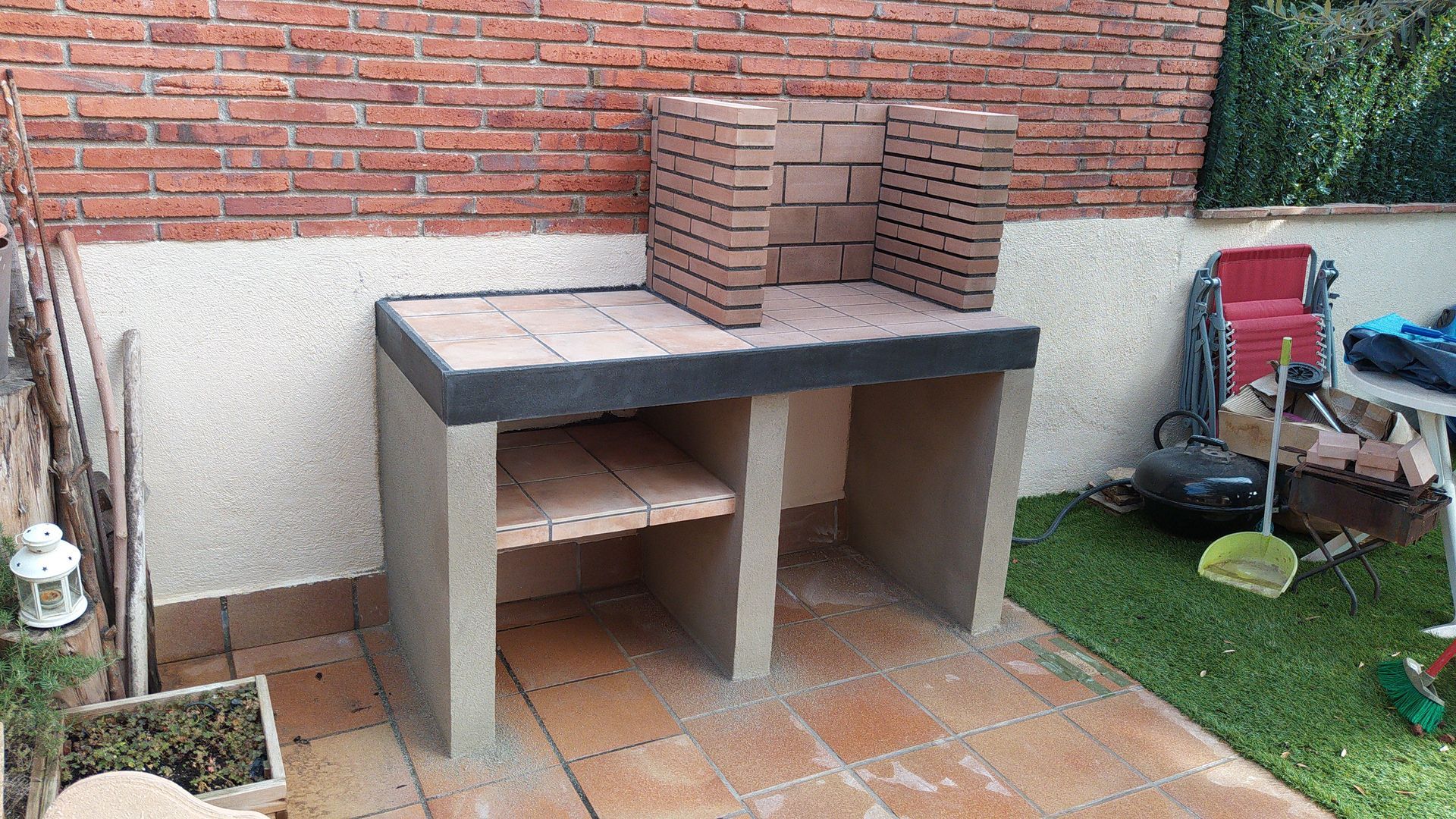 Una pared de ladrillos con una mesa y sillas delante.