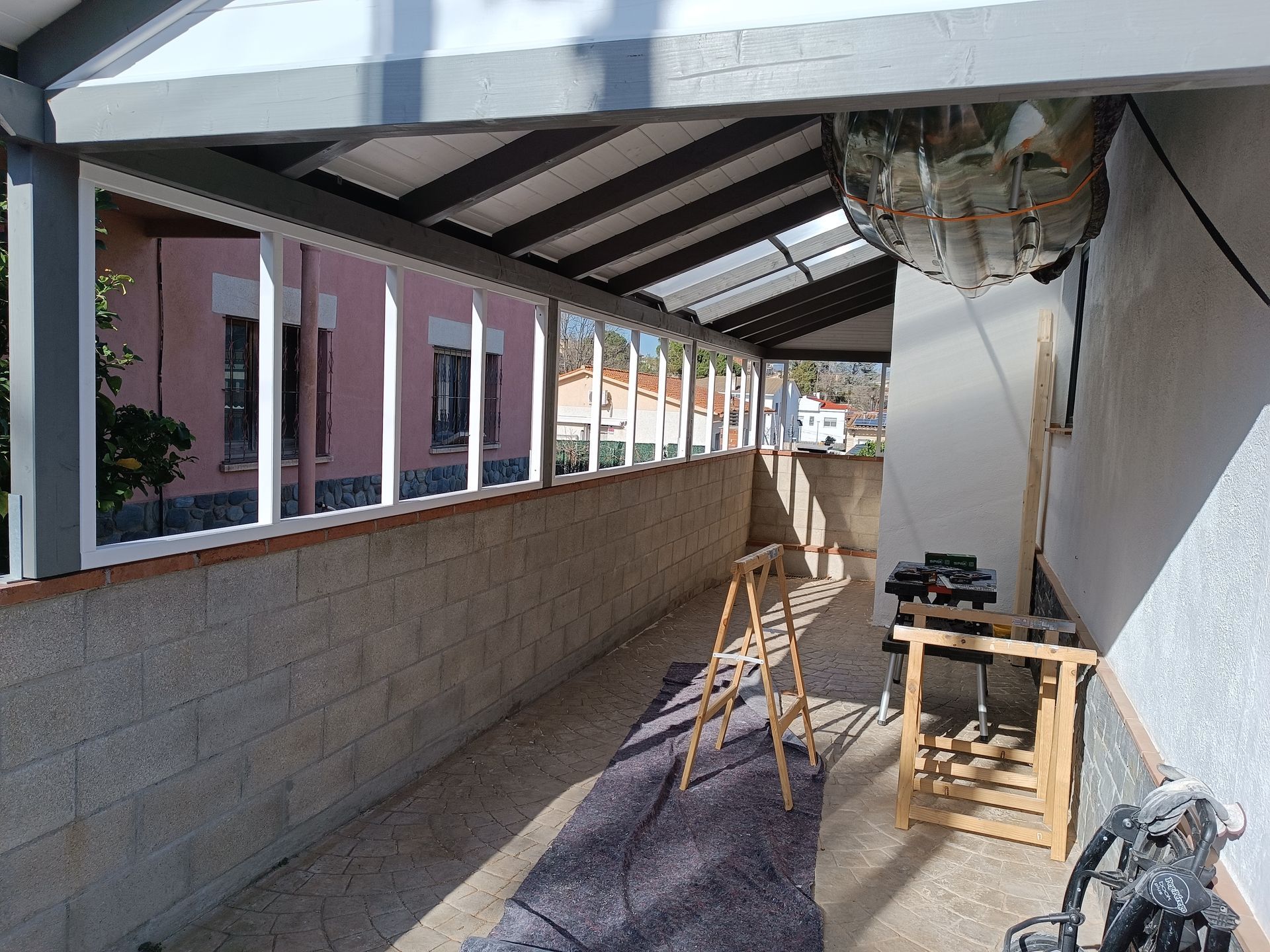 Una escalera de madera está colocada en el suelo debajo de un techo.