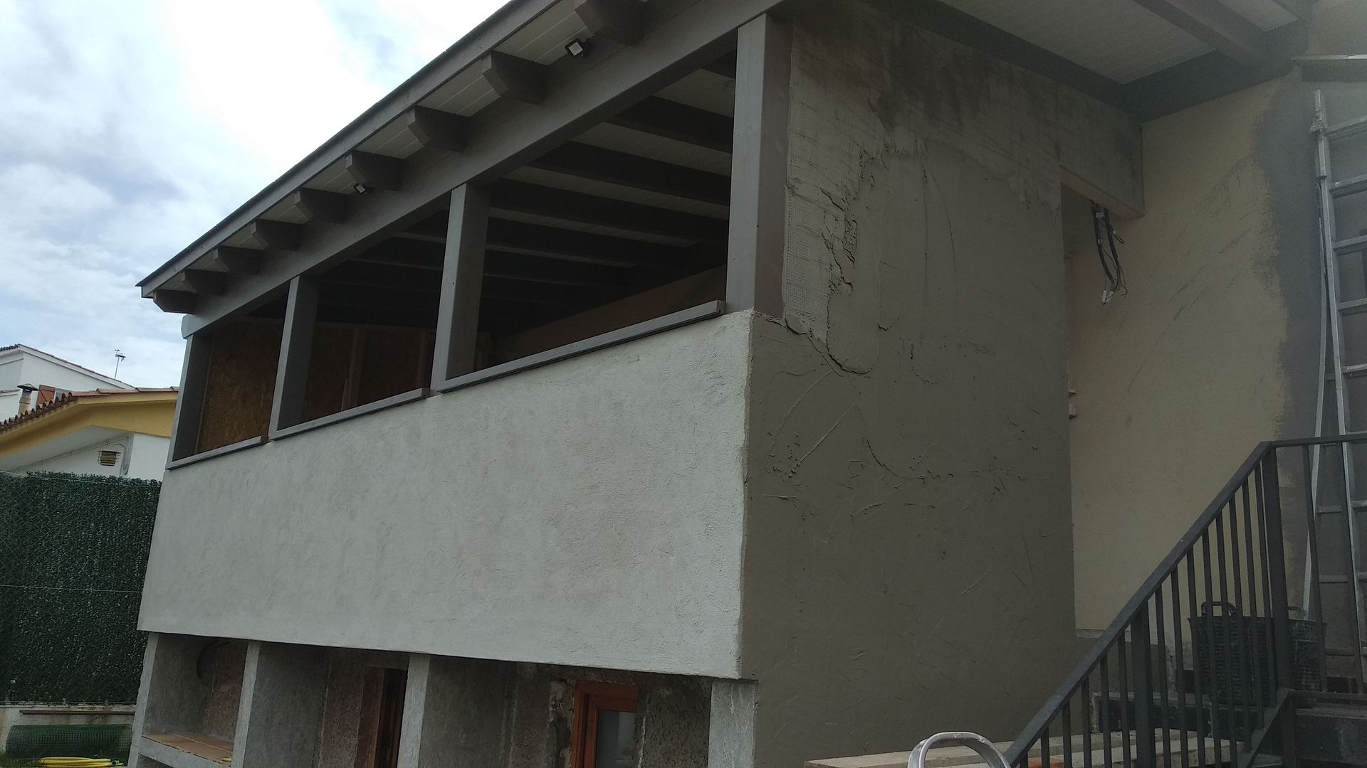 Una casa con balcón y escaleras al costado