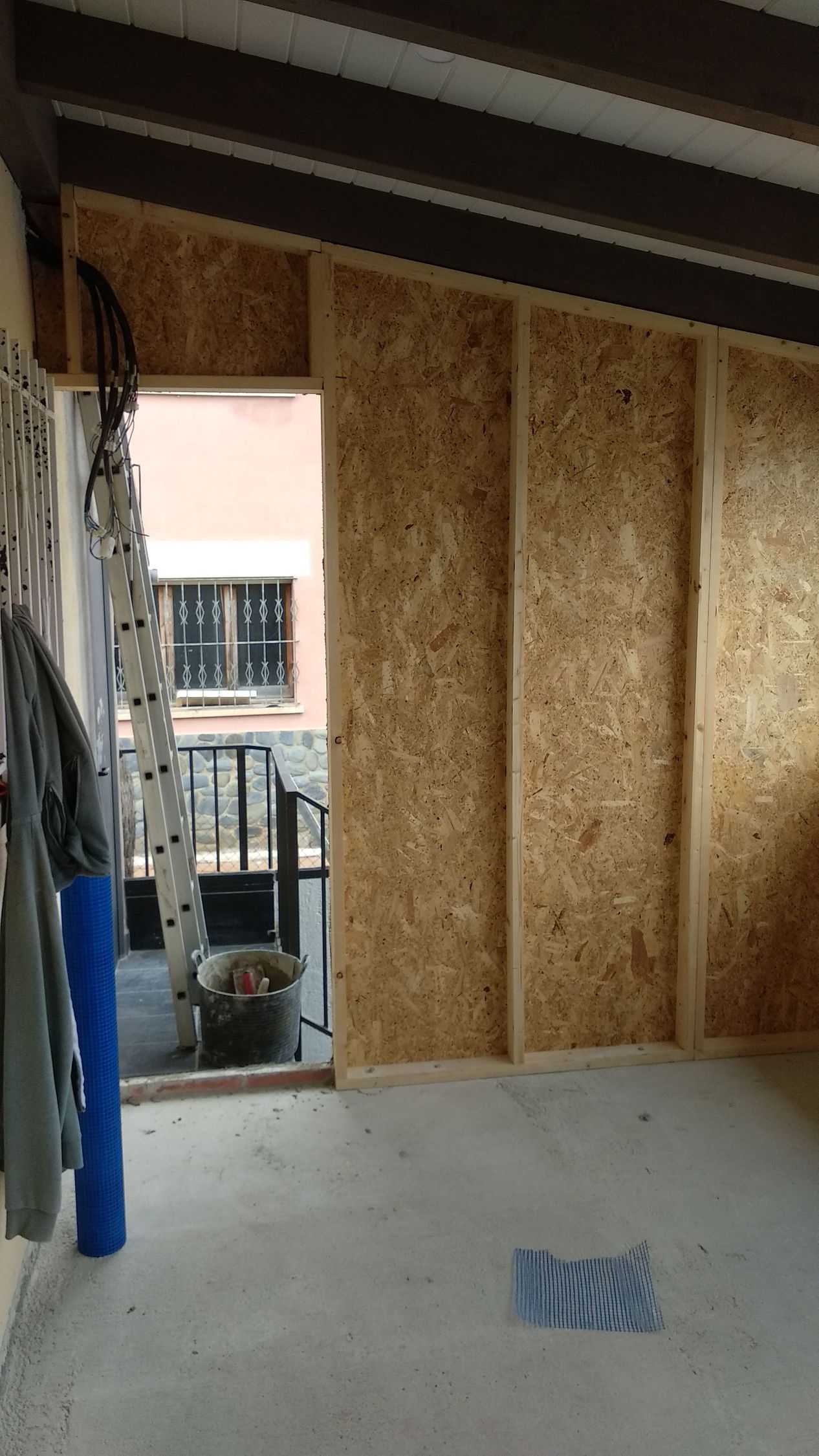 Una habitación con paredes de madera y una puerta que da a un balcón.