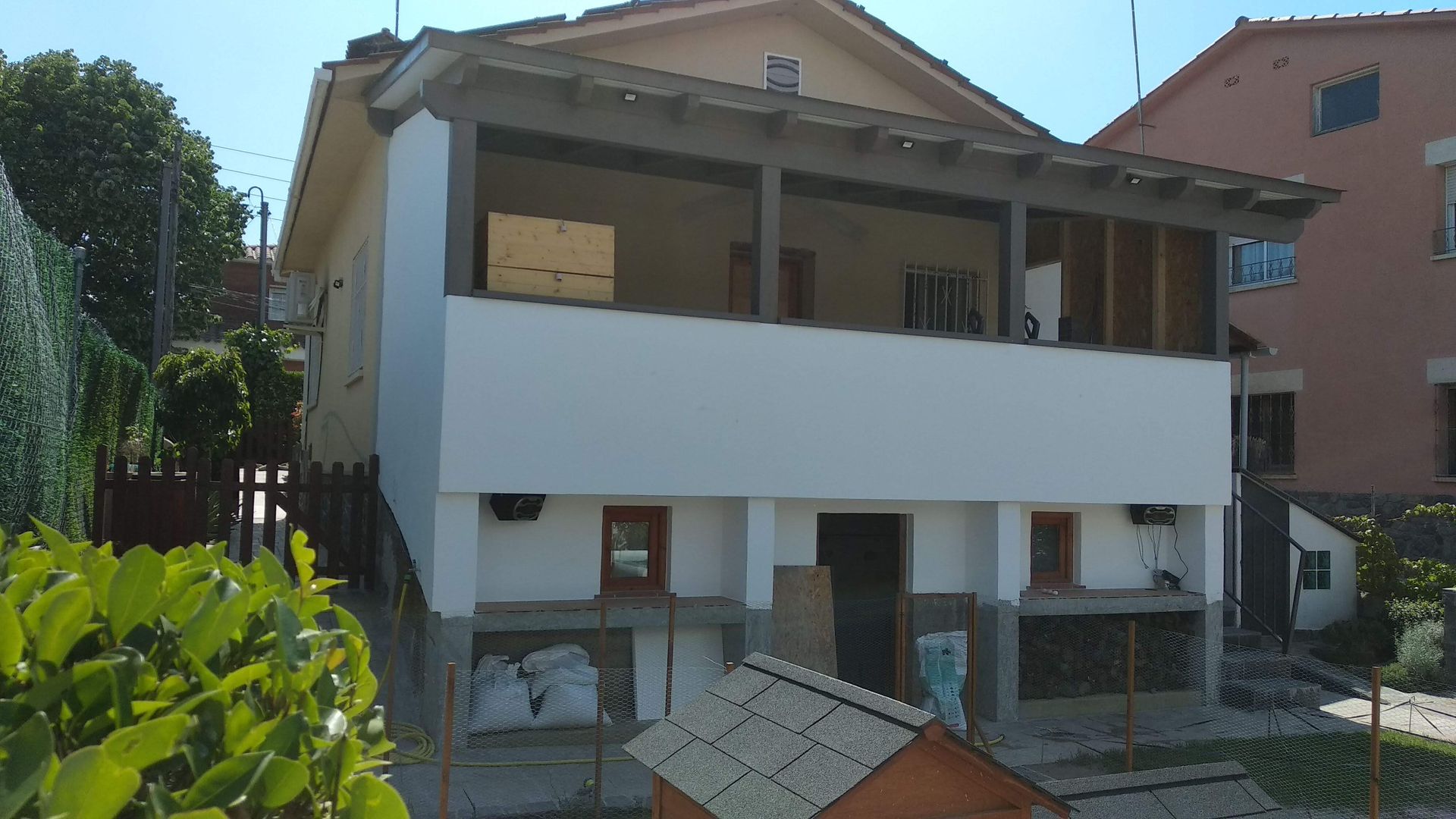 Una casa con una caseta para perro delante