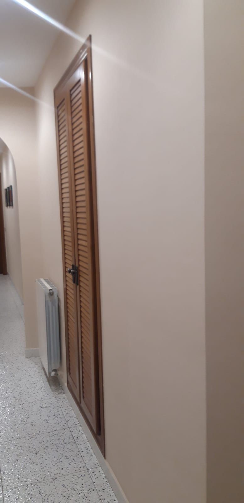 Un pasillo con dos puertas y un radiador en él.