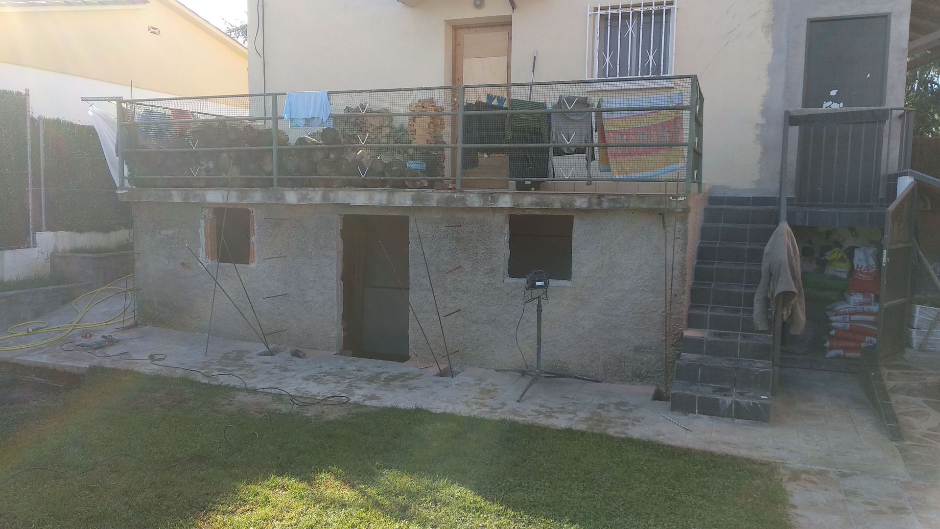 Una casa con balcón y escaleras en el patio trasero.