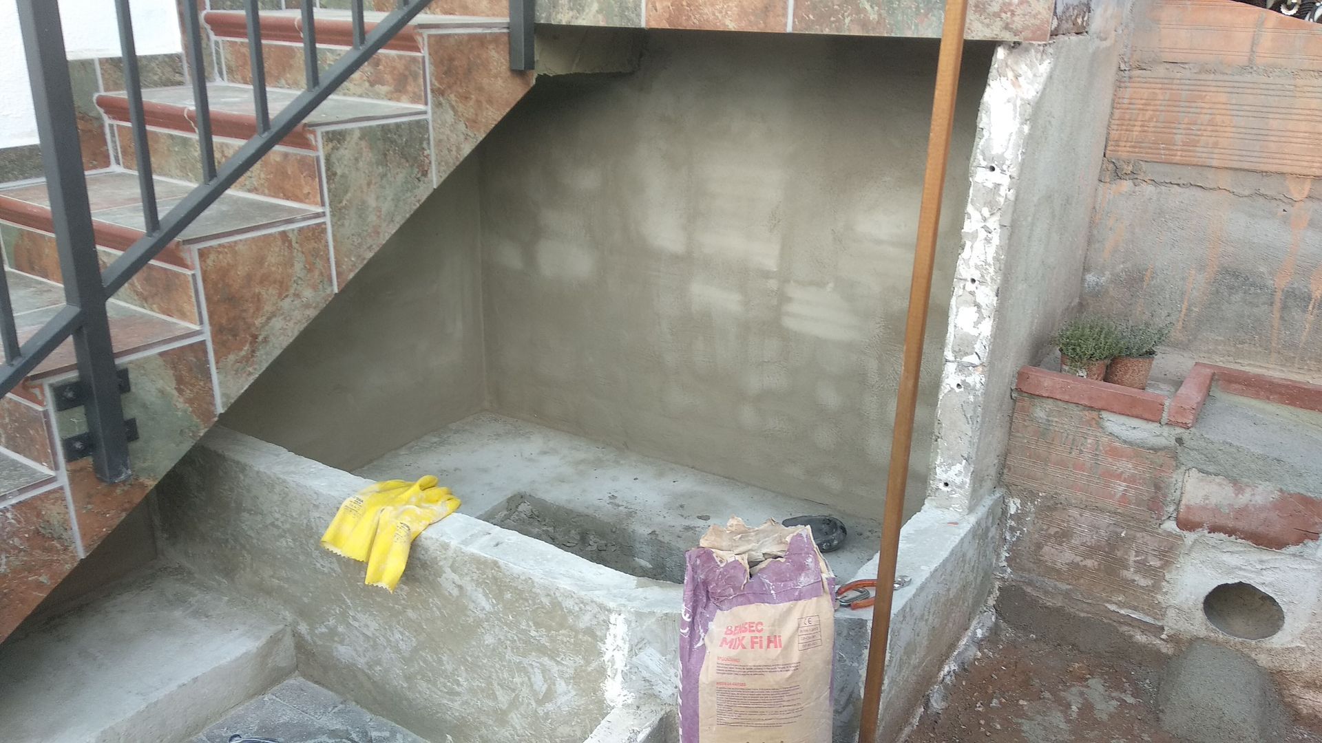 Una bolsa de cemento está al lado de un conjunto de escaleras.