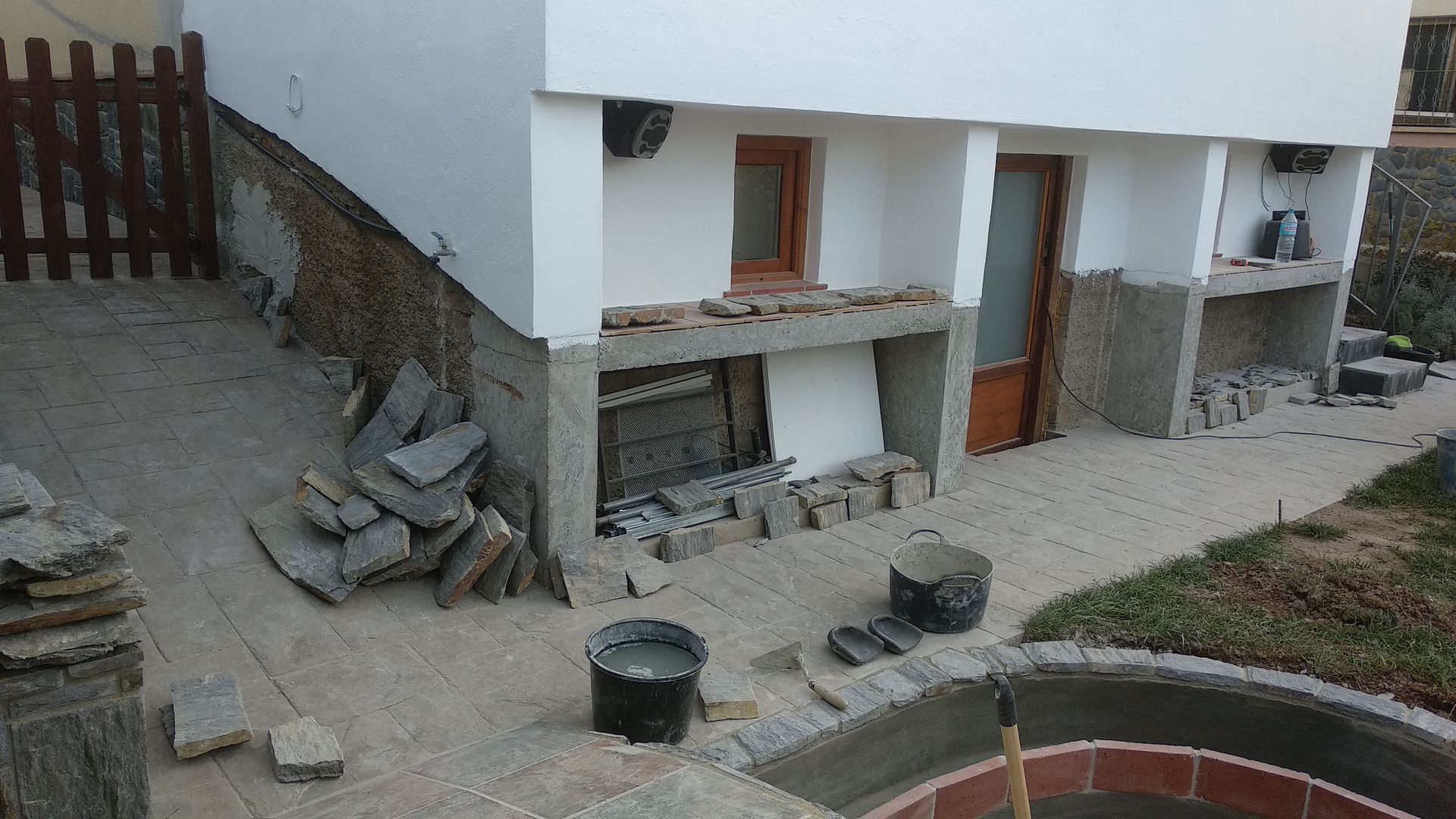 Se está remodelando una casa con una valla al fondo.