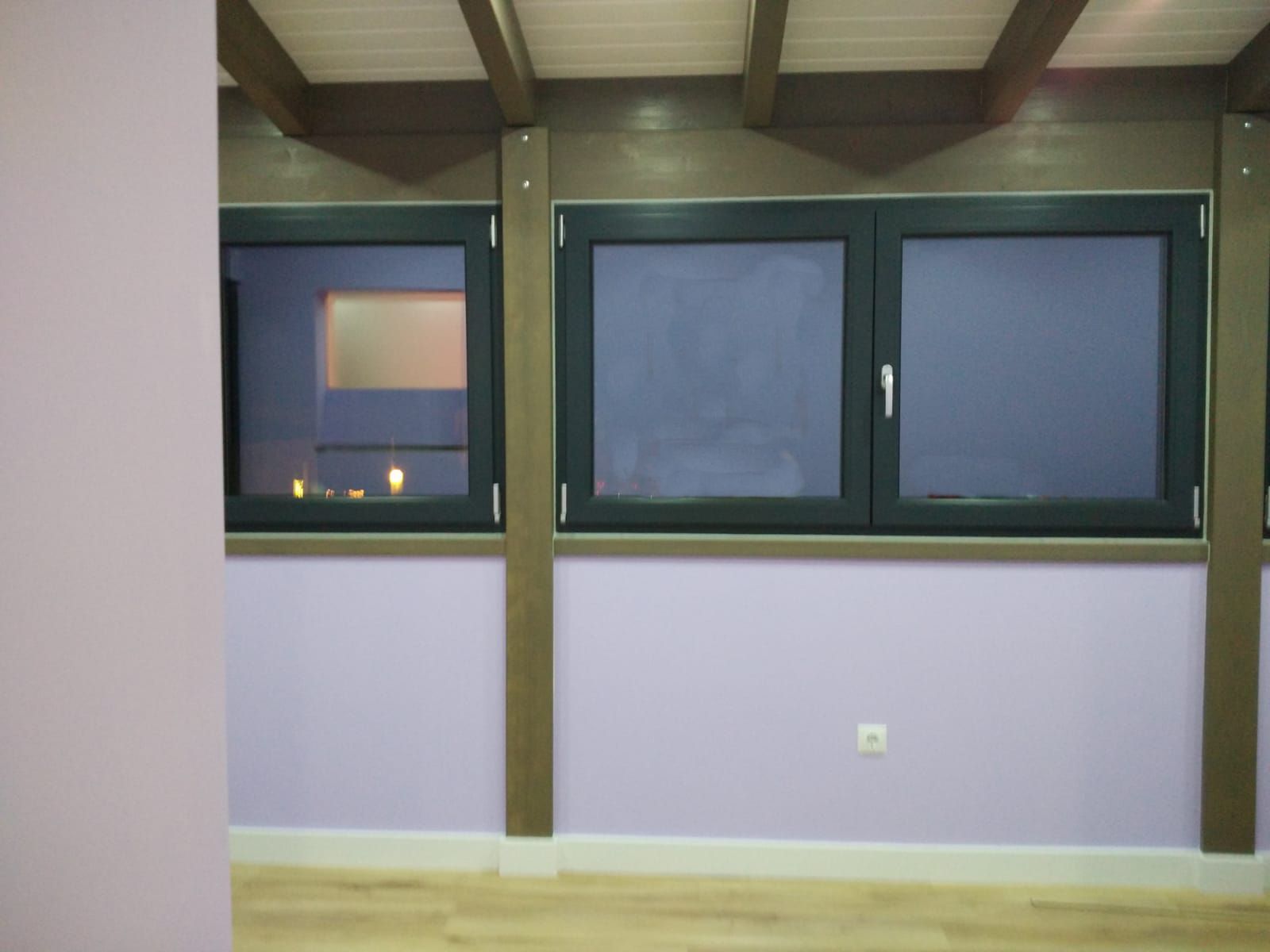 Una habitación con muchas ventanas y paredes moradas.