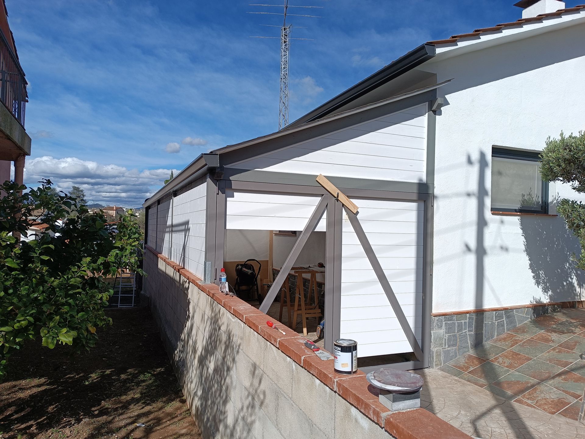 Una casa blanca con un techo que se está pintando