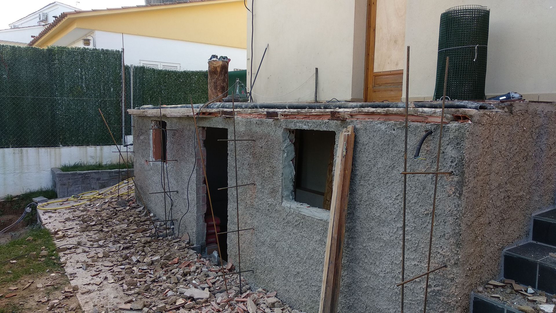 Un muro de hormigón con una ventana y escaleras delante.